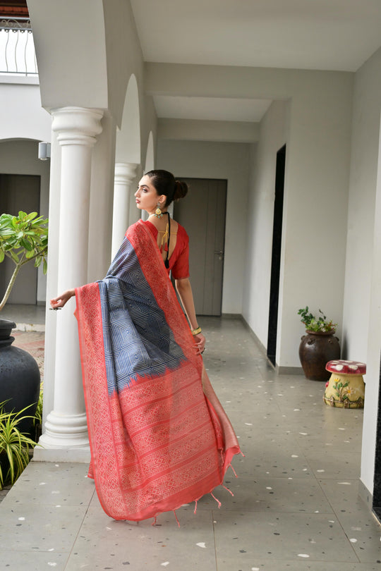 Grey & Red Soft Desi Tussar Silk Saree With Unique Ikkat Painted Pattern With Tradional Ikkat Pallu And Border With Traditional Tassels And Contrast Blouse Piece
